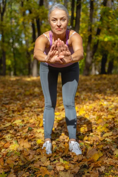 Mujer seria haciendo un ejercicio de espalda baja —  Fotos de Stock