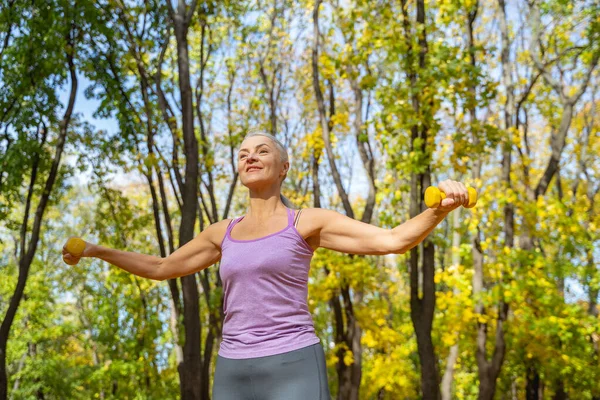 Mujer moderna tonificada haciendo ejercicio con pesas — Foto de Stock