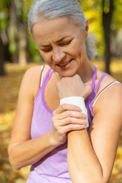 Reife Frau leidet an verstauchter Handgelenksverletzung — Stockfoto