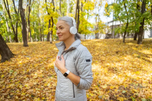 Sonriendo elegante dama de pie en un parque — Foto de Stock