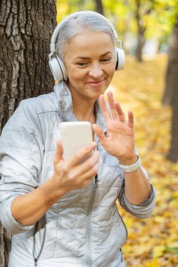 Parkta telefonla iletişim kuran bir kadın.