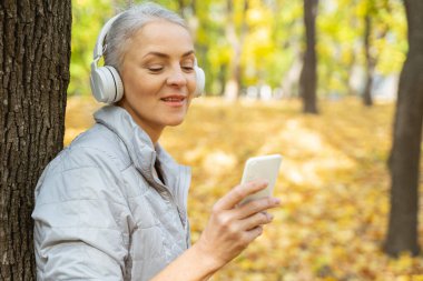 Memnun modern kadın akıllı telefonuna bakıyor.