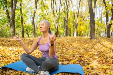 Kadın yogi parkta yoga yapıyor.