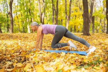 Konsantre, keyifli, sportif bayan bacaklarını çalıştırıyor.