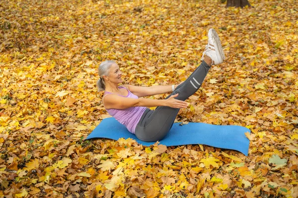 Starke fröhliche kaukasische Frau praktiziert Yoga im Freien — Stockfoto