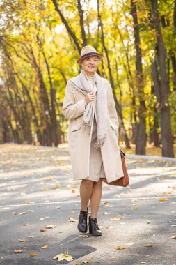 Hoş, olgun bir bayan, önüne bakıyor.