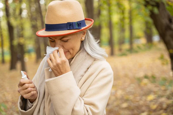 Malato signora matura utilizzando il suo fazzoletto all'aperto — Foto Stock