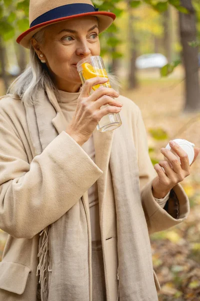 Mujer con una bebida de fruta mirando hacia otro lado —  Fotos de Stock