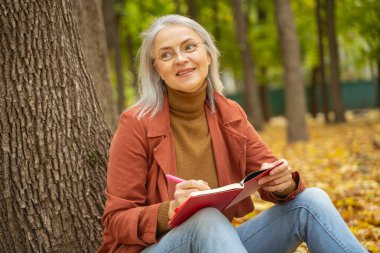 Hayalperest kadın not defterine not alıyor.