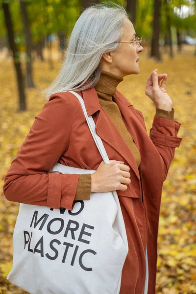 Señora con una bolsa en el hombro de pie al aire libre —  Fotos de Stock