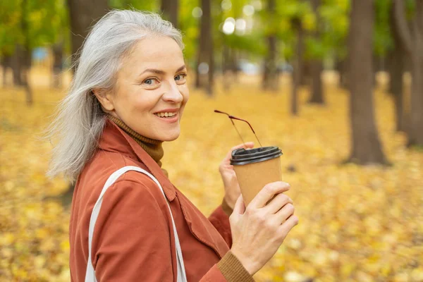 Happy woman holding eyeglasses in her hand — Stock Photo, Image