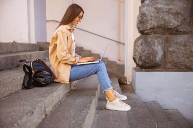 Sevdiği yerden uzaktan çalışan neşeli bir kadın.