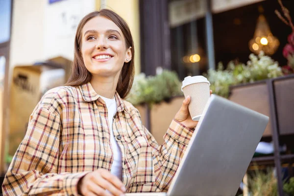 Vrouw kijkt naar de straat zittend in het café — Stockfoto