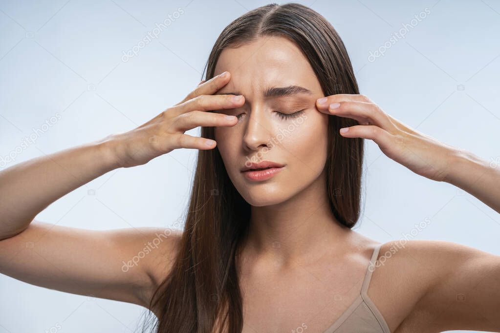 Worried brunette girl keeping her eyes closed
