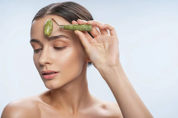 Pleased brunette woman taking care of her face — Stock Photo, Image