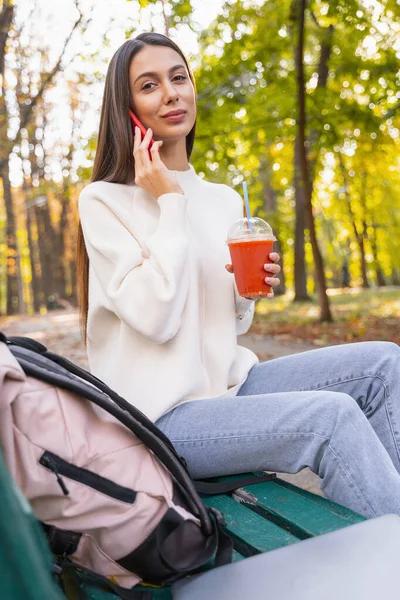 Pozitivní potěšená brunetka žena sedí na lavičce — Stock fotografie