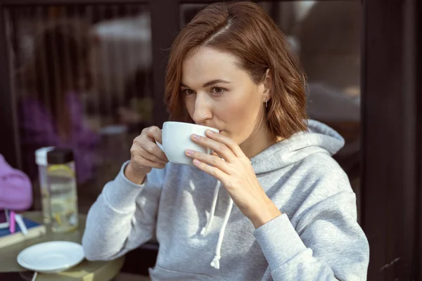 Porträtt av söt kvinna som dricker cappuccino — Stockfoto