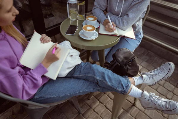 Сконцентрированная девушка держит свой блокнот на коленях — стоковое фото