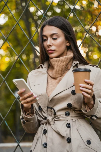 Concentrated long-haired brunette girl reading income message — Stock Photo, Image