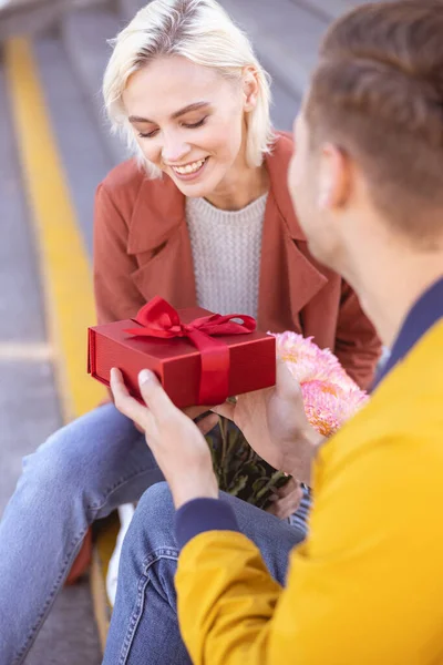 Kobieta jest trochę nieśmiała podczas otrzymywania prezentu urodzinowego — Zdjęcie stockowe