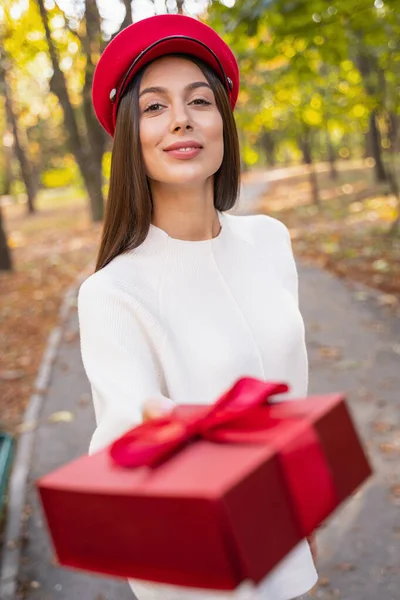 Niesamowite długowłosy kobieta dając pudełko z prezentem — Zdjęcie stockowe