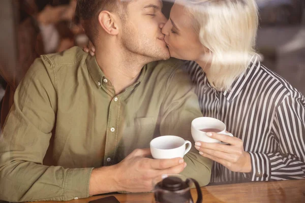 Счастливый красивый мужчина целует свою прекрасную девушку — стоковое фото