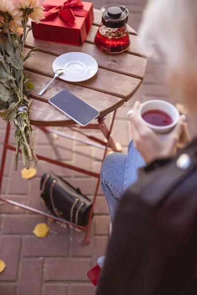 Jonge vrouw die thee drinkt in het café — Stockfoto