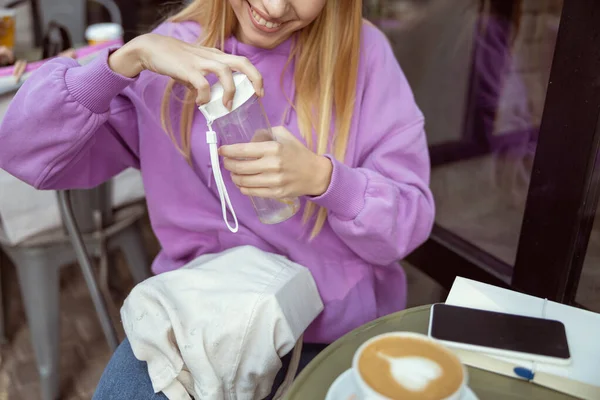 Rubia alegre mirando su elegante botella — Foto de Stock