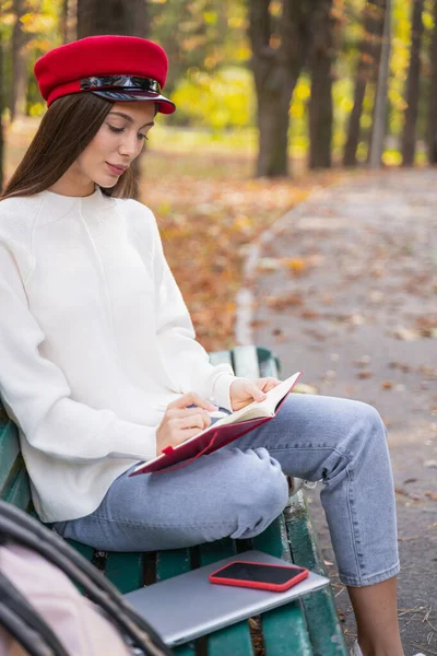 Zrelaksowana młoda kobieta robi notatki w swoim pamiętniku — Zdjęcie stockowe