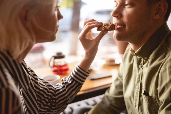 Hermosa mujer alimentando a su novio en el café —  Fotos de Stock