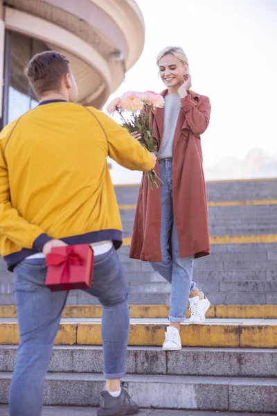 Junger Mann überreicht Blumenstrauß für seine Freundin — Stockfoto