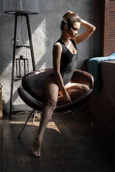 Дівчина розслабляється на стільці біля вікна — стокове фото