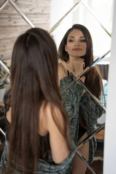 Dziewczyna patrzy na siebie w dużym lustrze — Zdjęcie stockowe