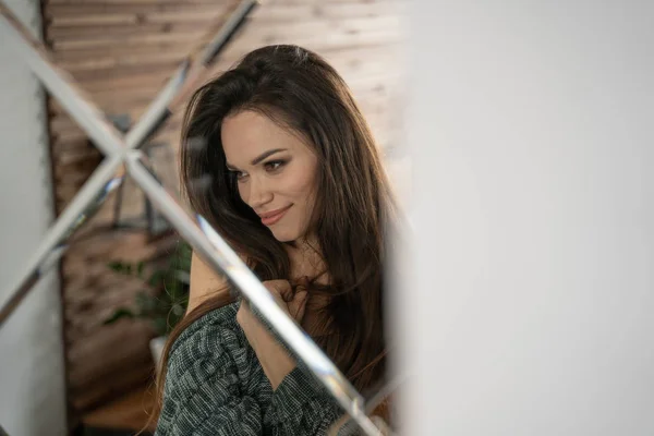 Hermosa mujer en cárdigan gris en apartamento mirando en el espejo —  Fotos de Stock