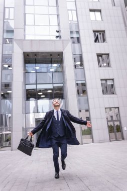 Mutlu esmer ofis çalışanı zevkle eve koşuyor.