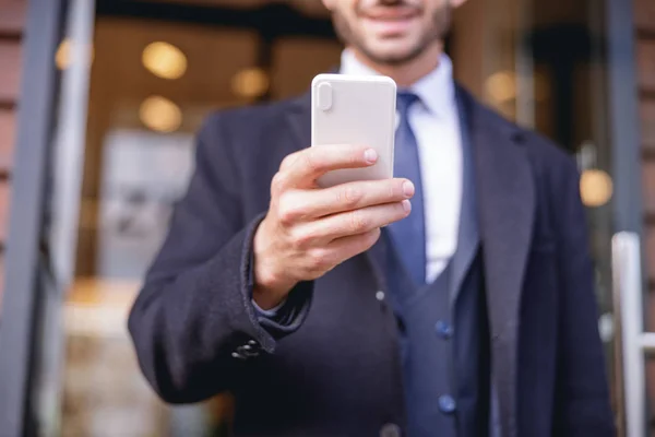 Foto enfocada en la mano masculina que sostiene el teléfono inteligente —  Fotos de Stock