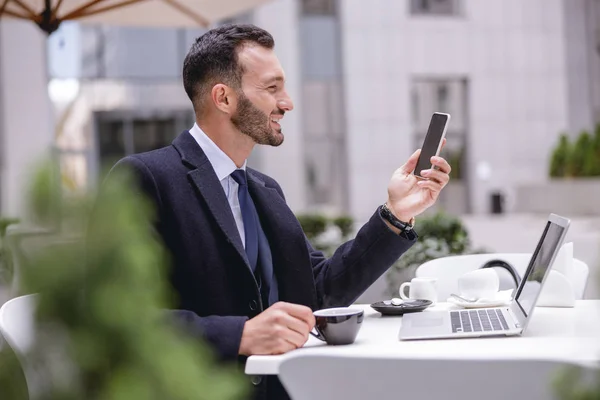 Yakışıklı esmer adam akıllı telefonuna bakıyor. — Stok fotoğraf