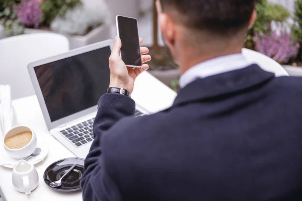 Närbild av brunett man som tittar på sin smartphone — Stockfoto