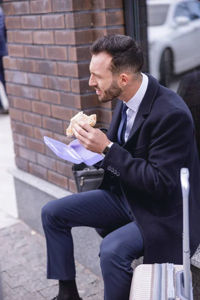 Homme d'affaires barbu affamé manger un sandwich — Photo
