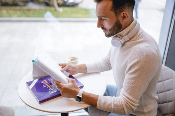 Allvarlig brunett manlig person som gör hemuppgift — Stockfoto