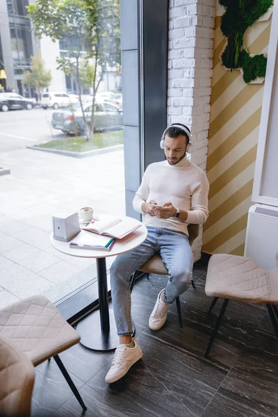 Розслаблений молодий брюнетка людина сидить в кафе — стокове фото