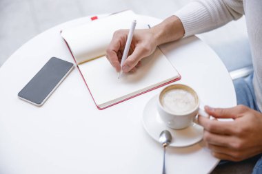 Not tutan erkek eline odaklanmış bir fotoğraf.