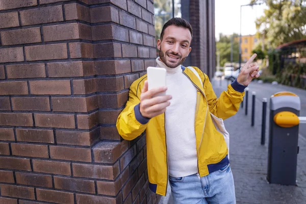 Pozitivní nadšený bruneta muž ukazuje na další budovu — Stock fotografie