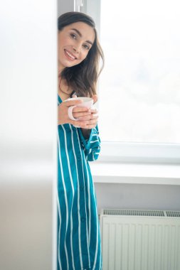 Mutlu bayan sabah çayının tadını çıkarıyor.