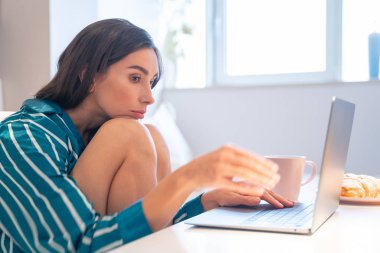 Dizüstü bilgisayarındaki fotoğrafıyla sıkılmış genç bir kadın.