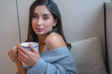 Güzel bayan elinde çay fincanıyla poz veriyor.