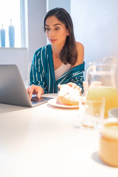 Signora calma con computer portatile moderno in cucina stock foto — Foto Stock