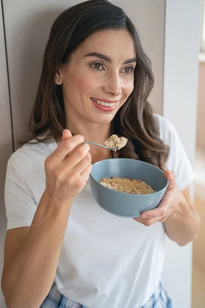 Mujer comiendo gachas favoritas para el desayuno foto de stock — Foto de Stock