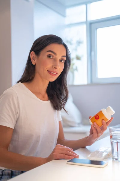 Smiling lady with pills at home stock photo — Stock Photo, Image
