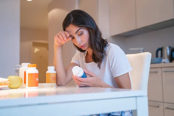 Unavená žena se čtyřmi lahvičkami pilulek stock fotografie — Stock fotografie